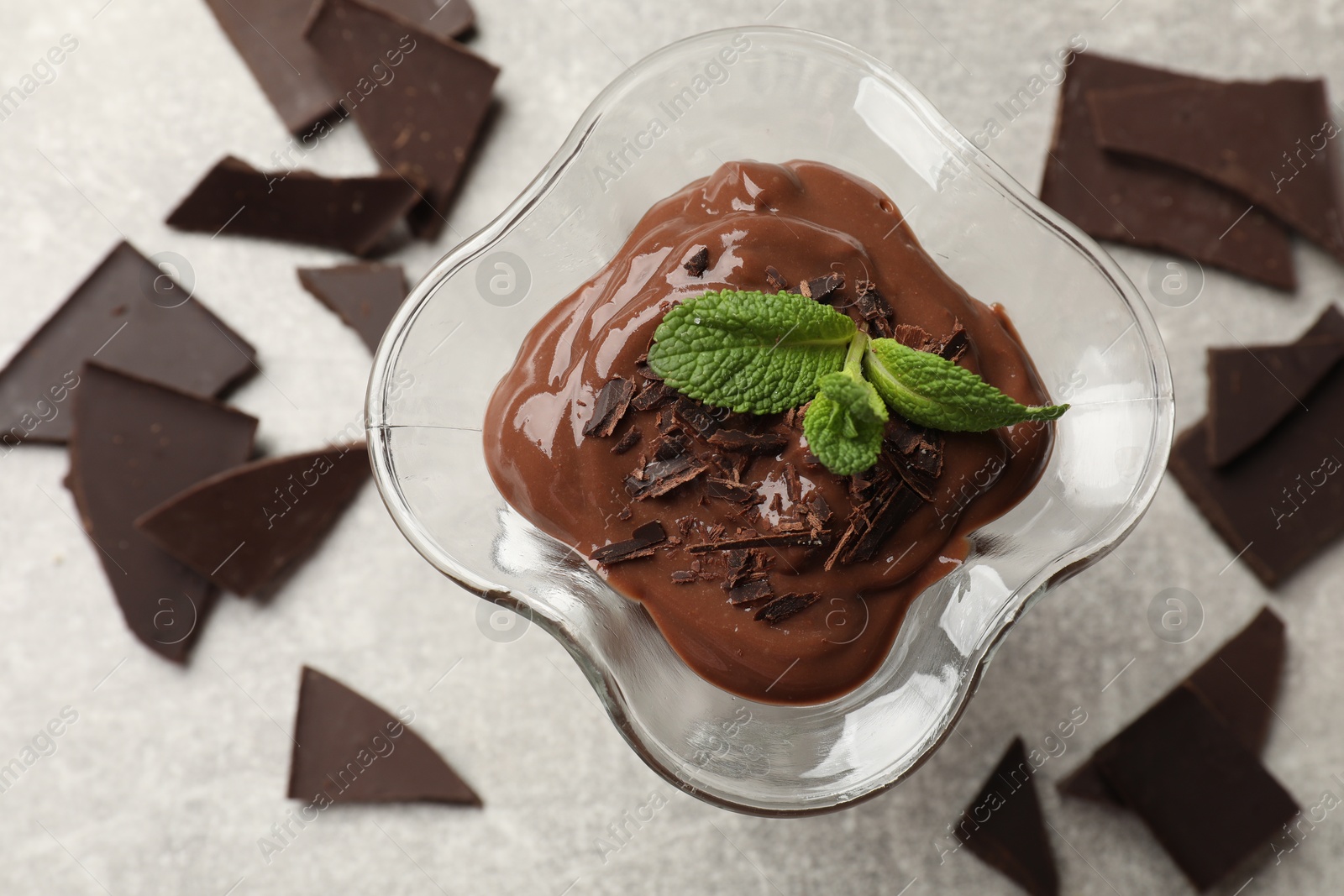 Photo of Delicious chocolate mousse in glass dessert bowl on grey table, top view