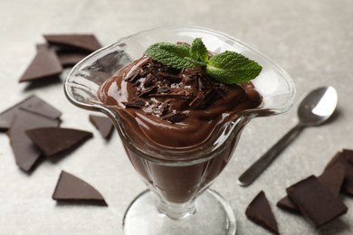 Photo of Delicious chocolate mousse in glass dessert bowl on grey table, closeup