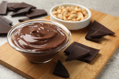 Photo of Delicious chocolate mousse in glass bowl and ingredients on grey table, closeup