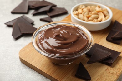 Photo of Delicious chocolate mousse in glass bowl and ingredients on grey table, closeup