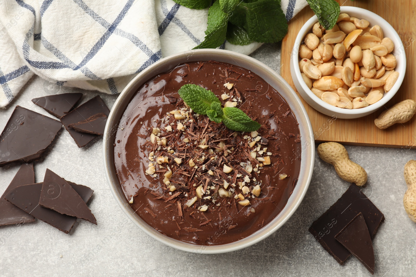 Photo of Delicious chocolate mousse in bowl and ingredients on grey table, flat lay