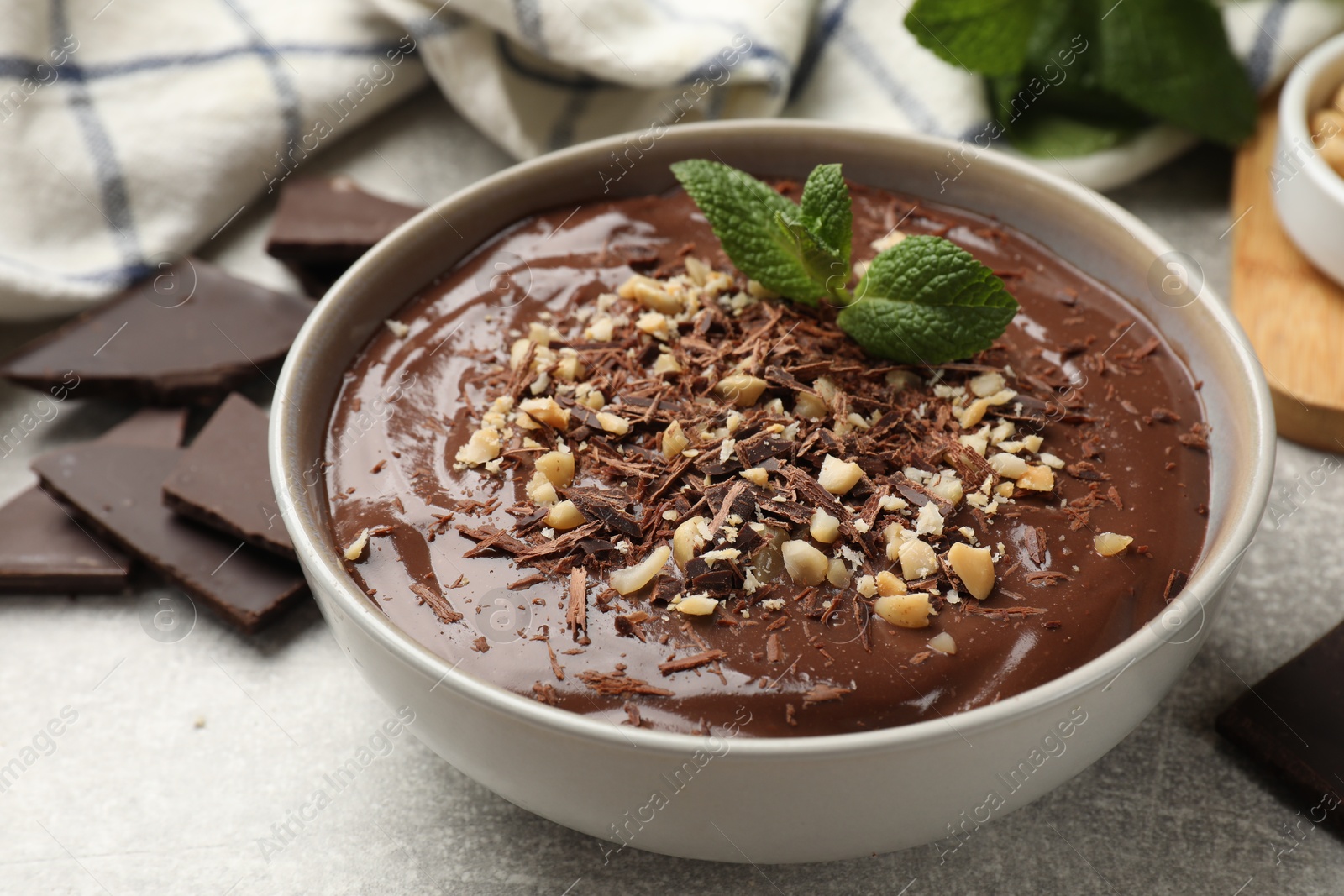 Photo of Delicious chocolate mousse in bowl grey table, closeup