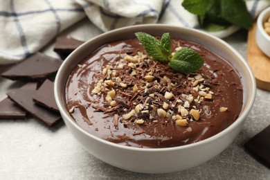 Photo of Delicious chocolate mousse in bowl grey table, closeup