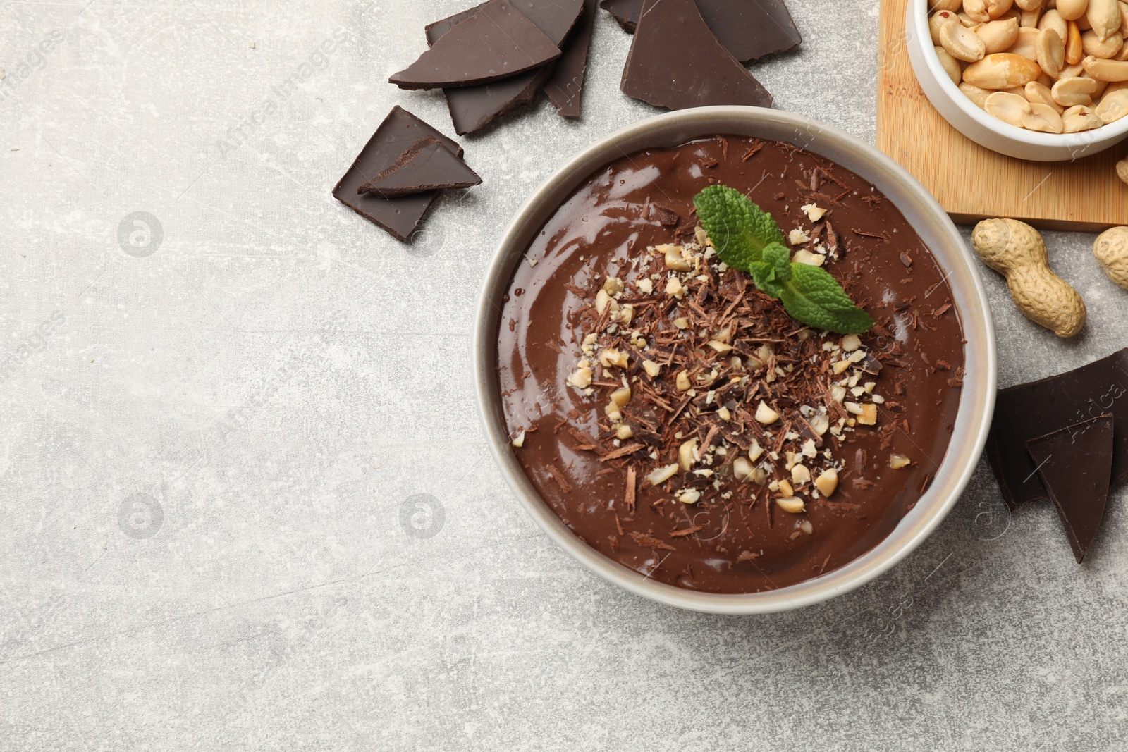 Photo of Delicious chocolate mousse in bowl and ingredients on grey table, flat lay. Space for text