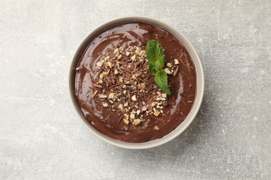 Photo of Delicious chocolate mousse in bowl on grey table, top view