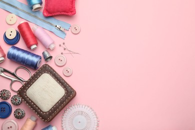 Photo of Different sewing supplies on pink background, flat lay. Space for text