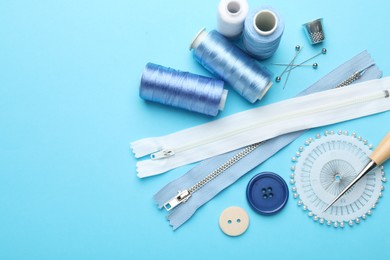 Photo of Different sewing supplies on light blue background, flat lay. Space for text