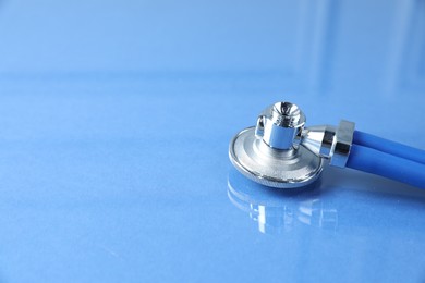 Photo of Stethoscope on blue background, closeup. Space for text