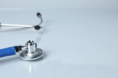 Photo of Stethoscope on light background, closeup. Space for text