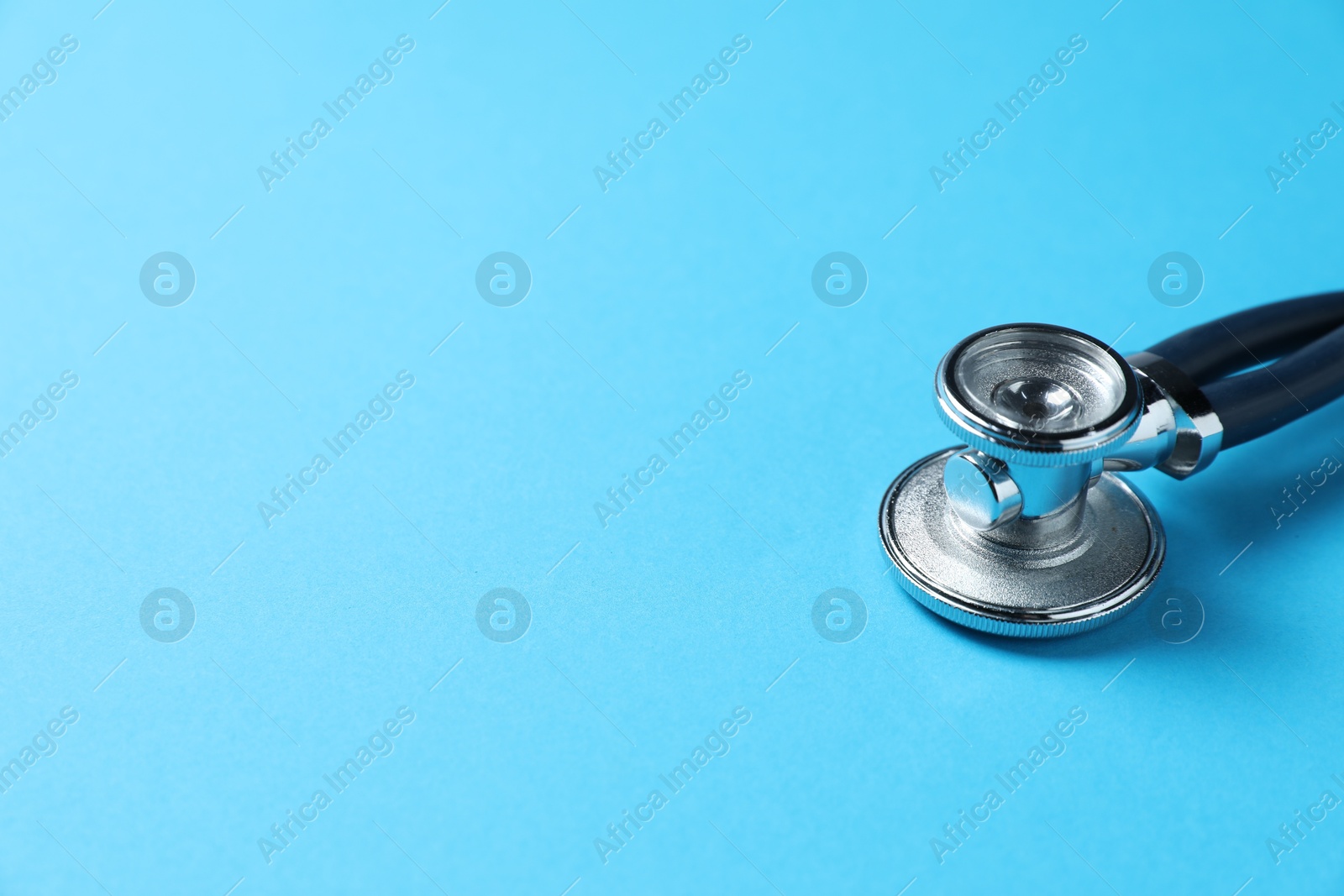 Stethoscope on light blue background, closeup. Space for text Photo of Stethoscope on light blue background, closeup. Space for text
