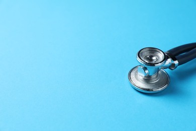 Photo of Stethoscope on light blue background, closeup. Space for text