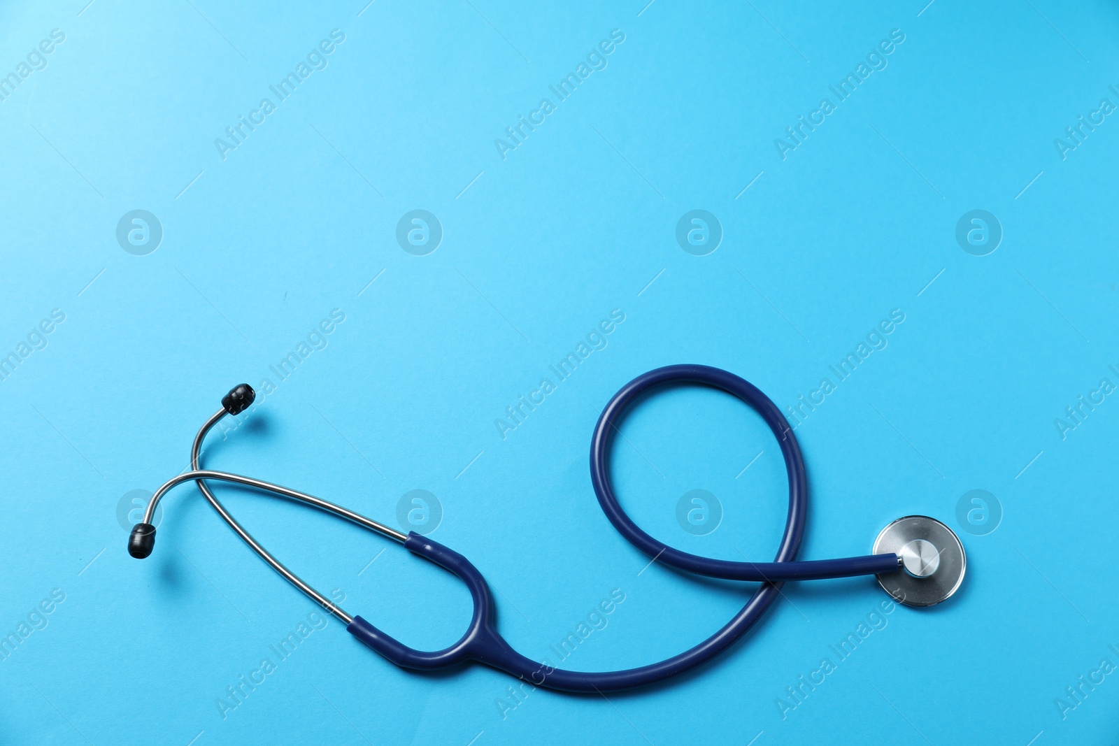 Stethoscope on light blue background, top view. Space for text Photo of Stethoscope on light blue background, top view. Space for text