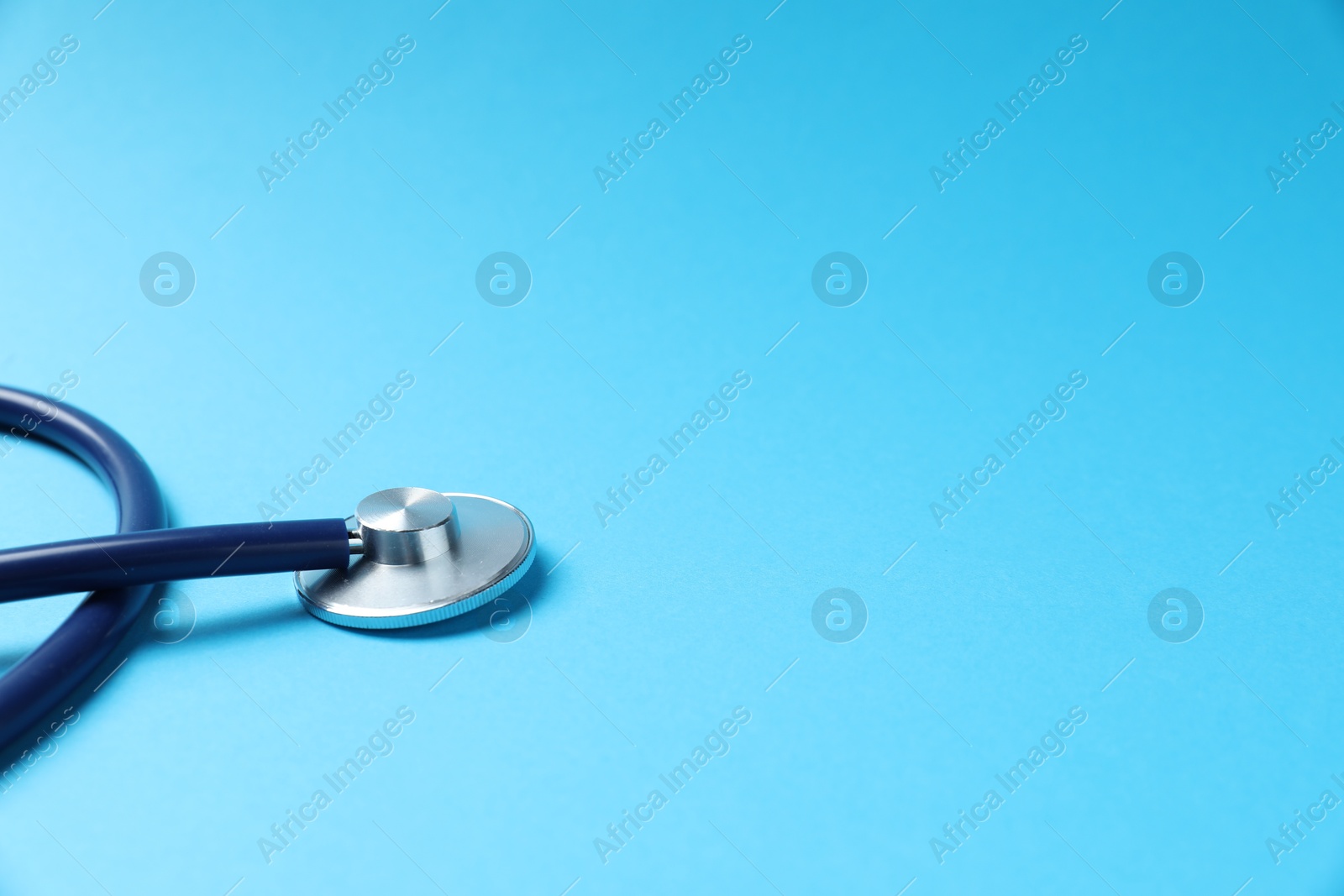 Stethoscope on light blue background, closeup. Space for text Photo of Stethoscope on light blue background, closeup. Space for text