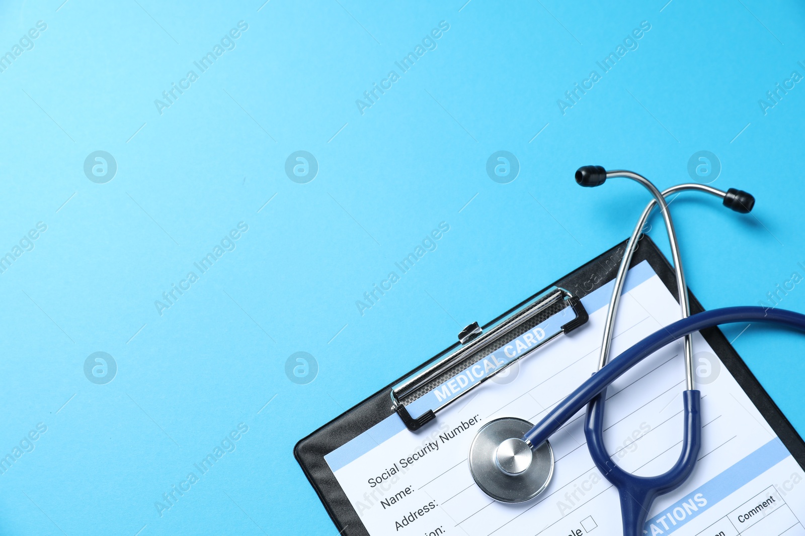 Stethoscope and medical card form on light blue background, top view. Space for text Photo of Stethoscope and medical card form on light blue background, top view. Space for text