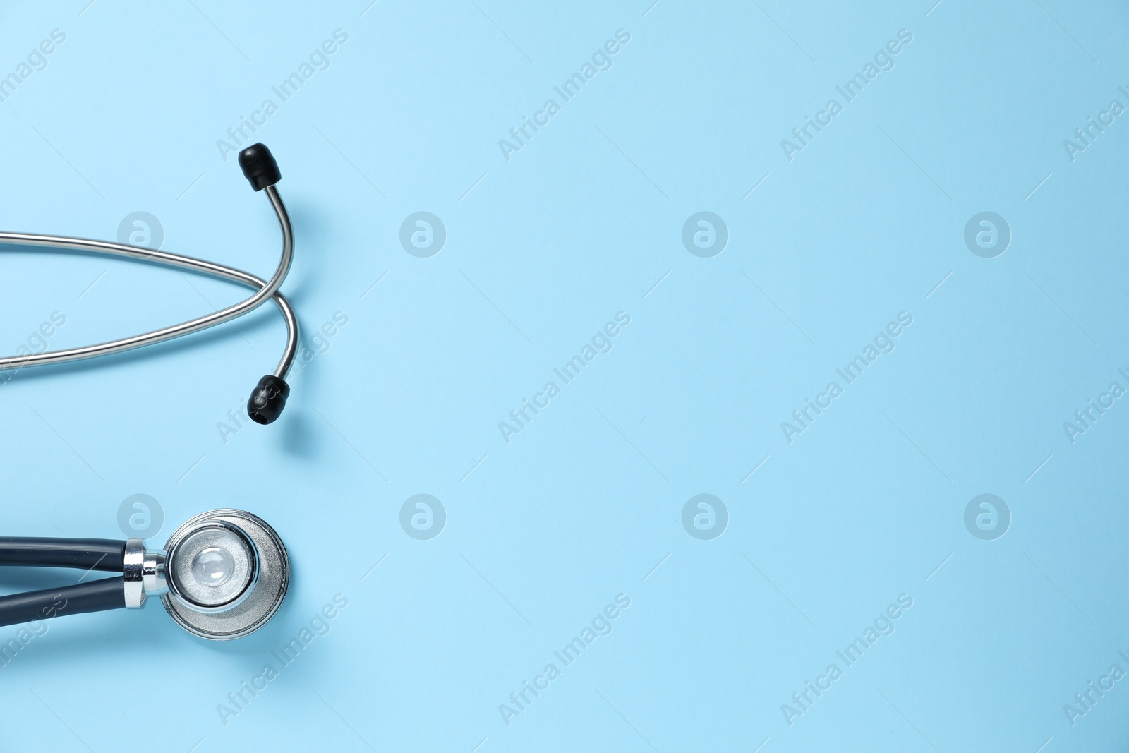 Stethoscope on light blue background, top view. Space for text Photo of Stethoscope on light blue background, top view. Space for text