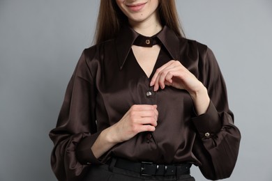 Photo of Beautiful woman in stylish outfit on grey background, closeup