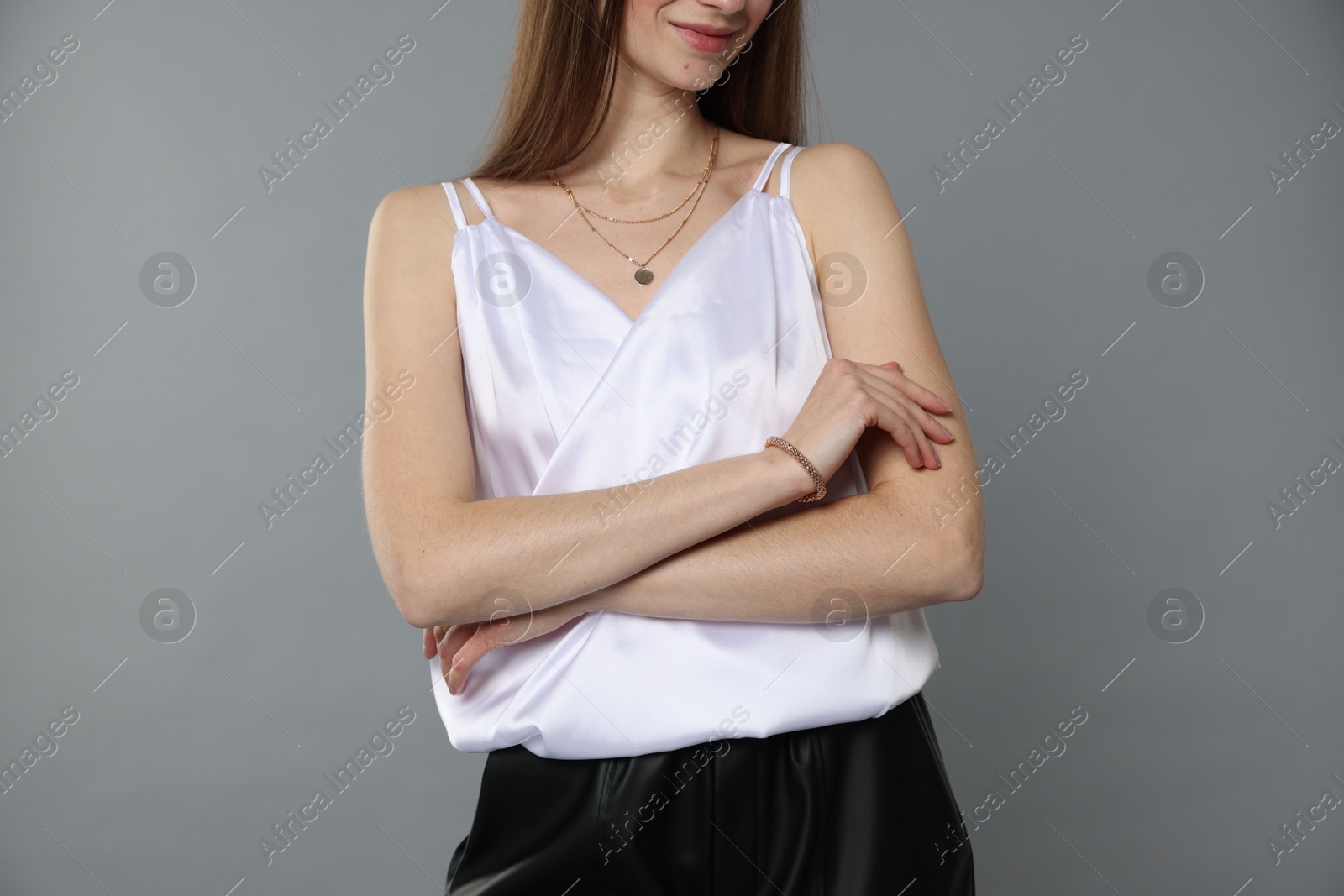 Photo of Beautiful woman in stylish outfit on grey background, closeup