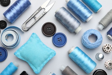 Photo of Different sewing supplies on light grey background, flat lay