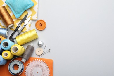 Photo of Different sewing supplies on light grey background, flat lay. Space for text