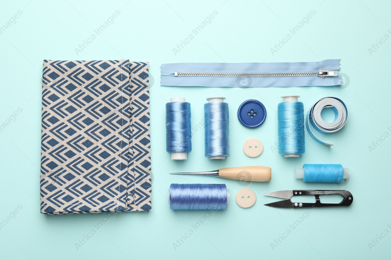 Photo of Different sewing supplies on light blue background, flat lay