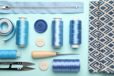 Photo of Different sewing supplies on light blue background, flat lay