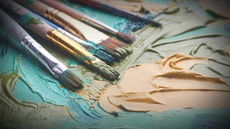 Image of Artist's palette with many brushes and mixed paints, closeup