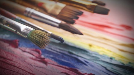 Image of Artist's canvas with many brushes and mixed paints, closeup