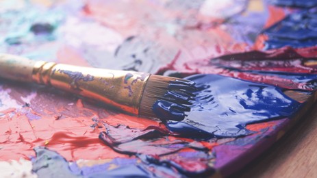 Image of Artist's palette with brush and mixed paints, closeup