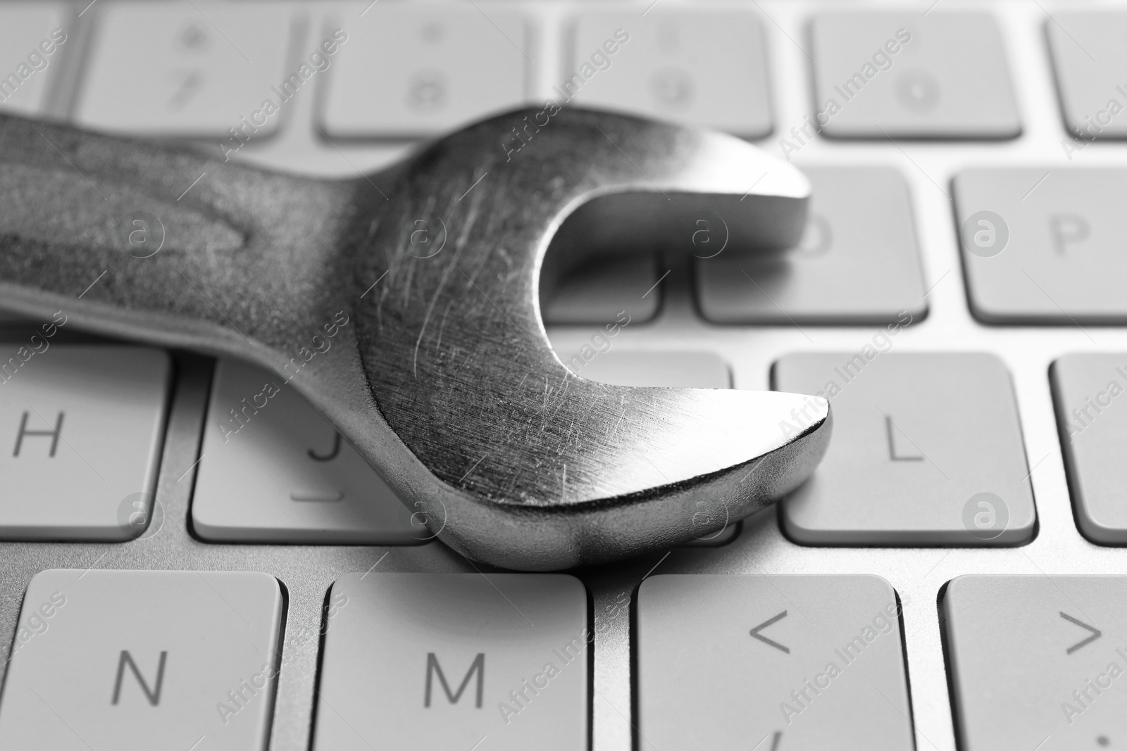 Photo of Technical support concept. Wrench on keyboard, closeup