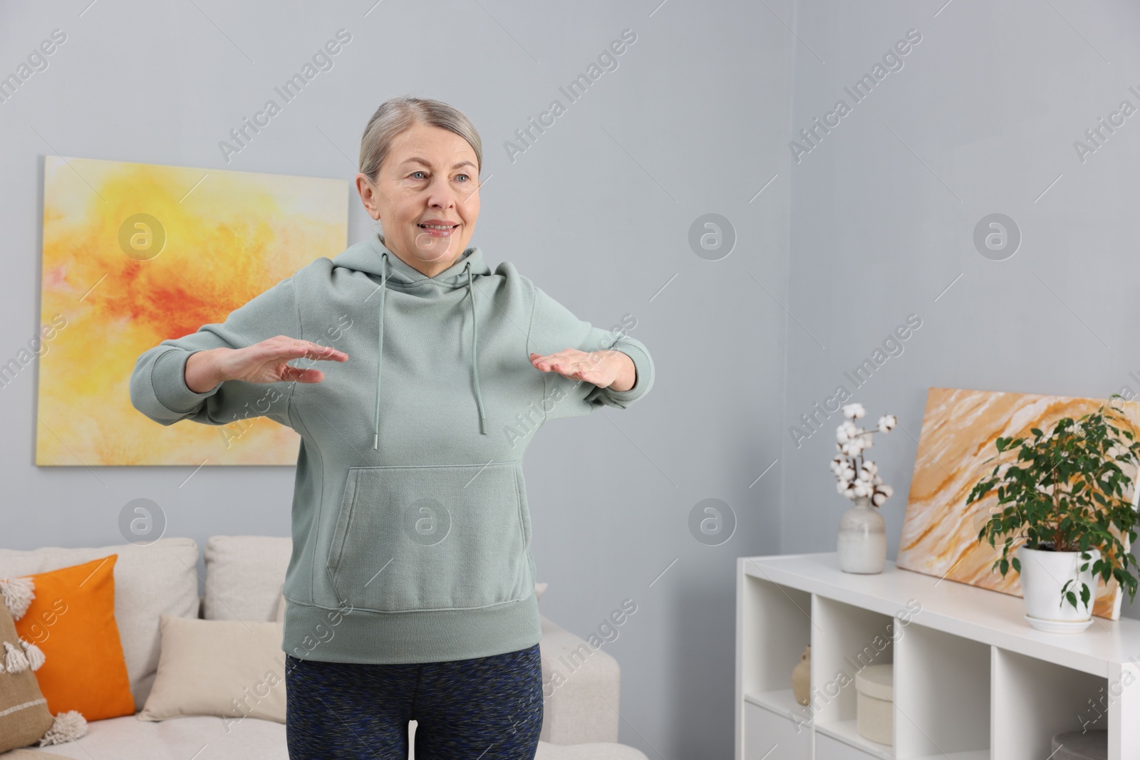 Photo of Smiling elderly woman doing exercise at home