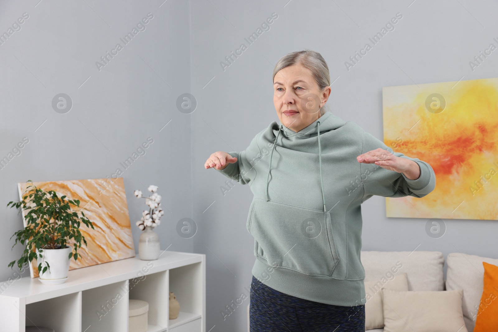 Photo of Elderly woman doing exercise at home. Healthy leisure