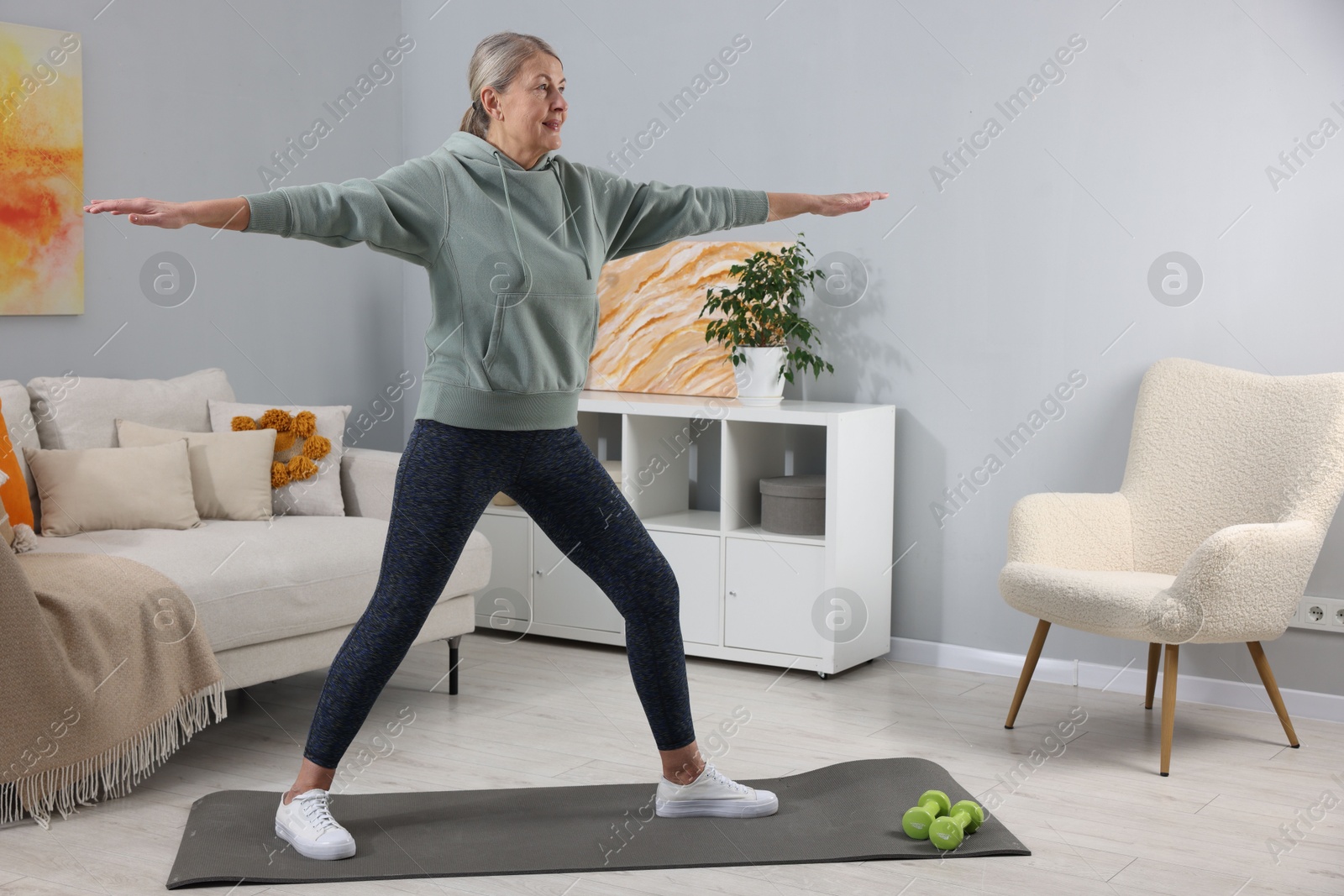 Photo of Elderly woman doing exercise at home. Healthy leisure