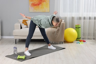 Photo of Elderly woman doing exercise at home. Healthy leisure