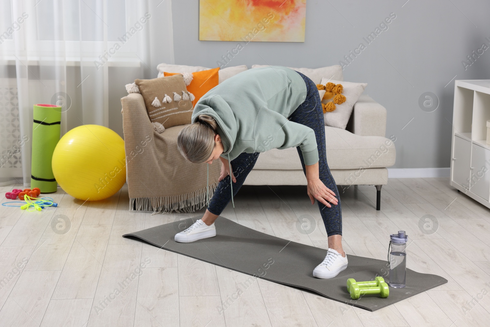 Photo of Elderly woman doing exercise at home. Healthy leisure