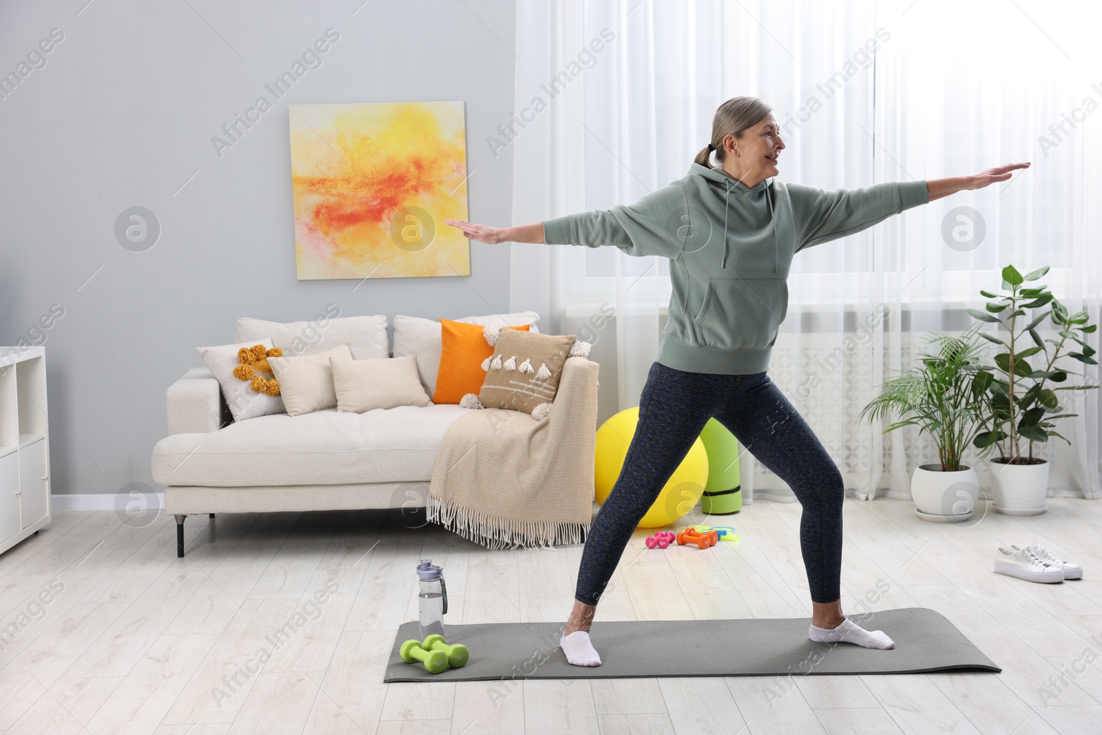 Photo of Smiling elderly woman doing exercise at home