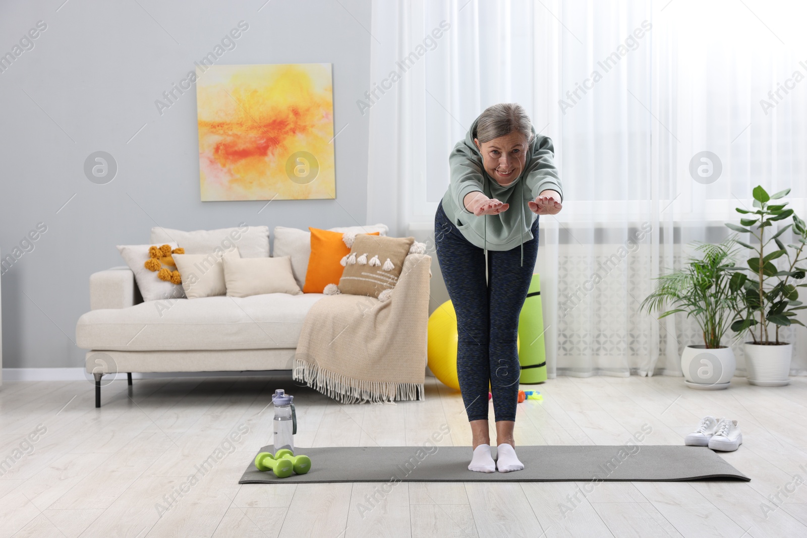 Photo of Smiling elderly woman doing exercise at home