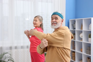 Photo of Elderly couple exercising at home. Healthy leisure