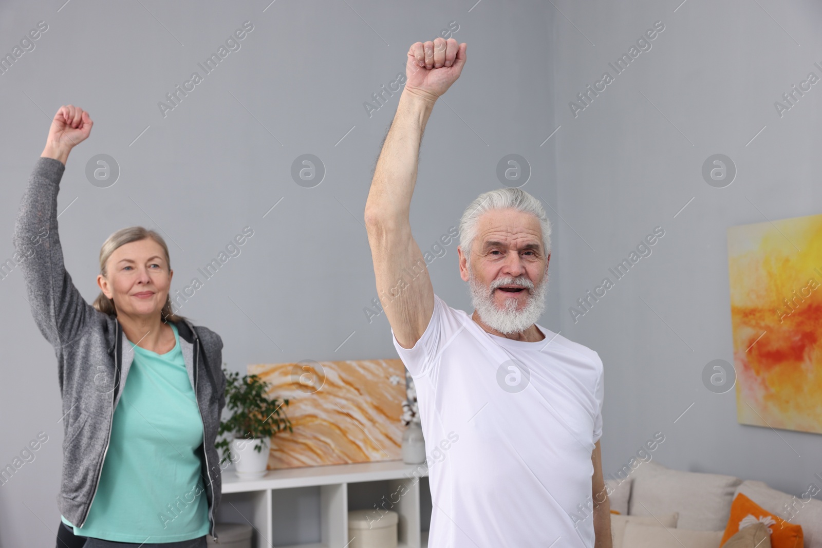 Photo of Elderly couple exercising at home. Healthy leisure