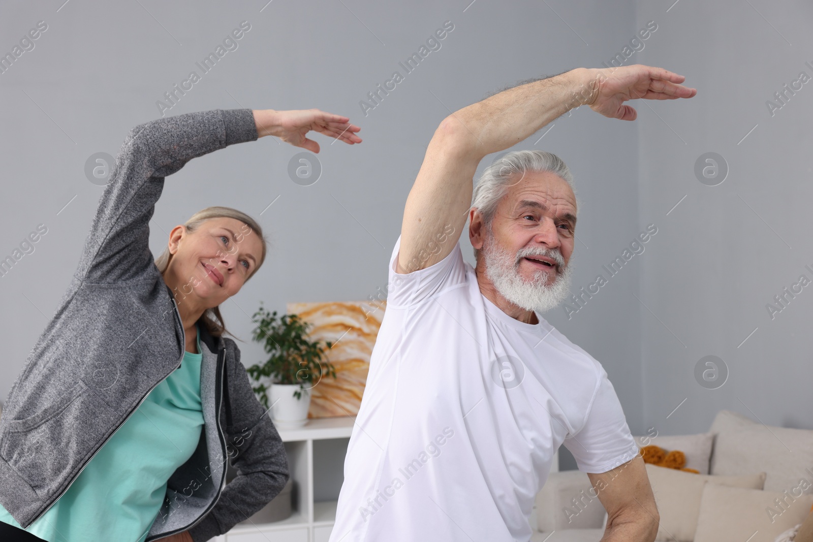 Photo of Elderly couple exercising at home. Healthy leisure