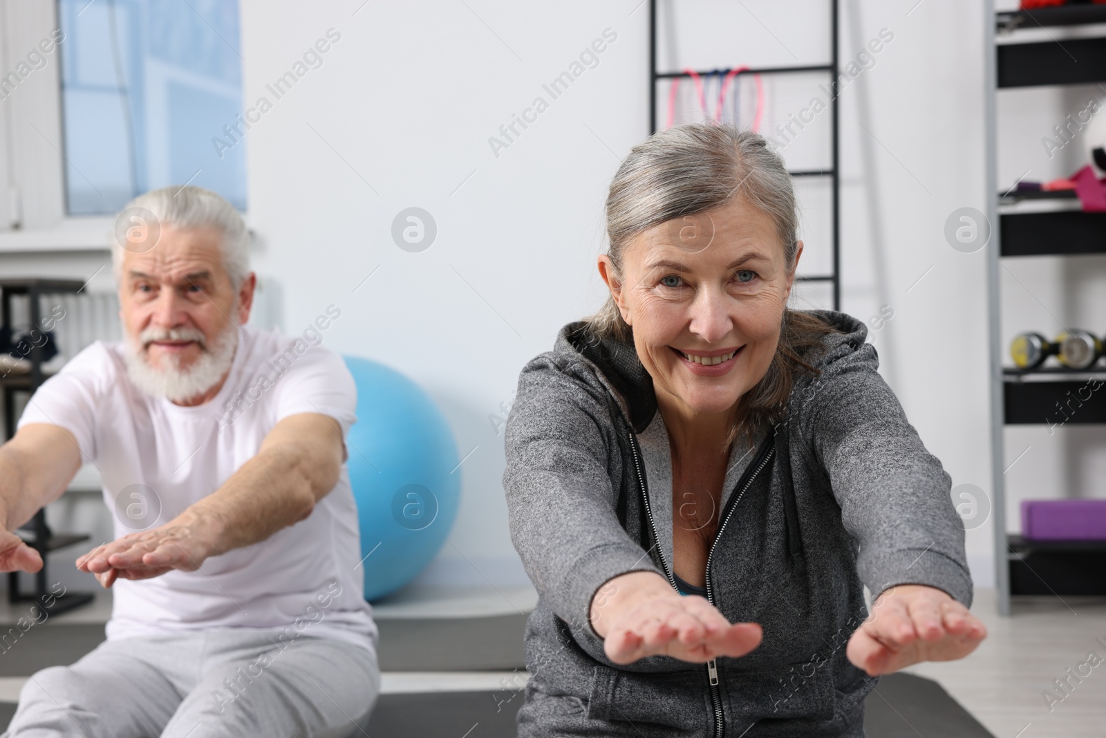 Photo of Elderly couple exercising at home. Healthy leisure