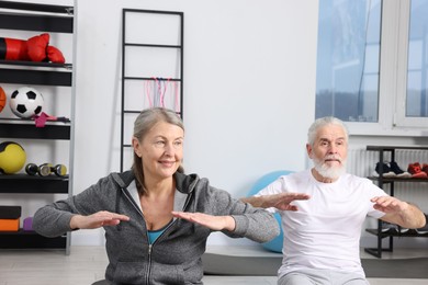 Photo of Elderly couple exercising at home. Healthy leisure