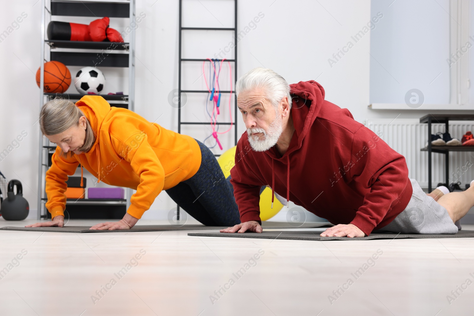 Photo of Elderly couple exercising at home. Healthy leisure