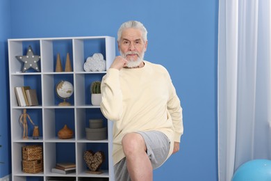 Photo of Elderly man exercising at home. Healthy leisure