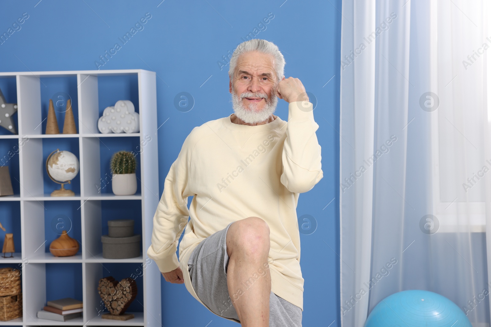 Photo of Elderly man exercising at home. Healthy leisure