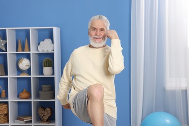 Photo of Elderly man exercising at home. Healthy leisure