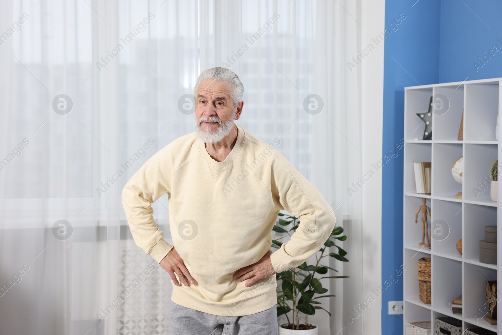 Photo of Elderly man exercising at home. Healthy leisure