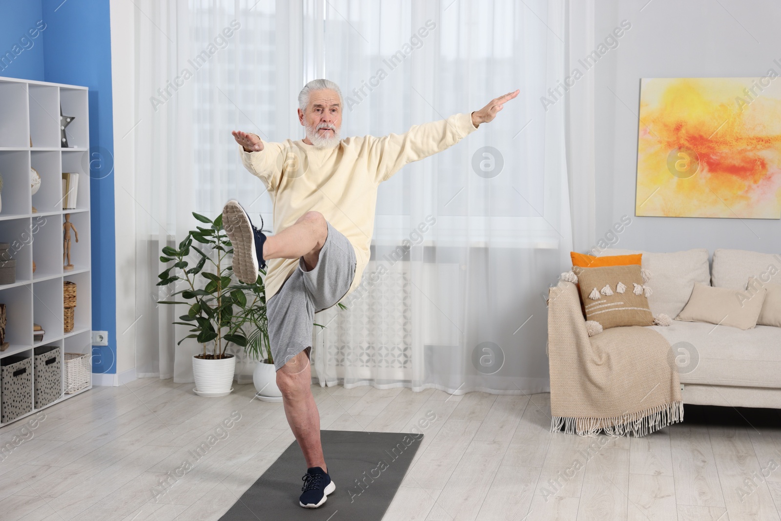 Photo of Elderly man exercising at home. Healthy leisure