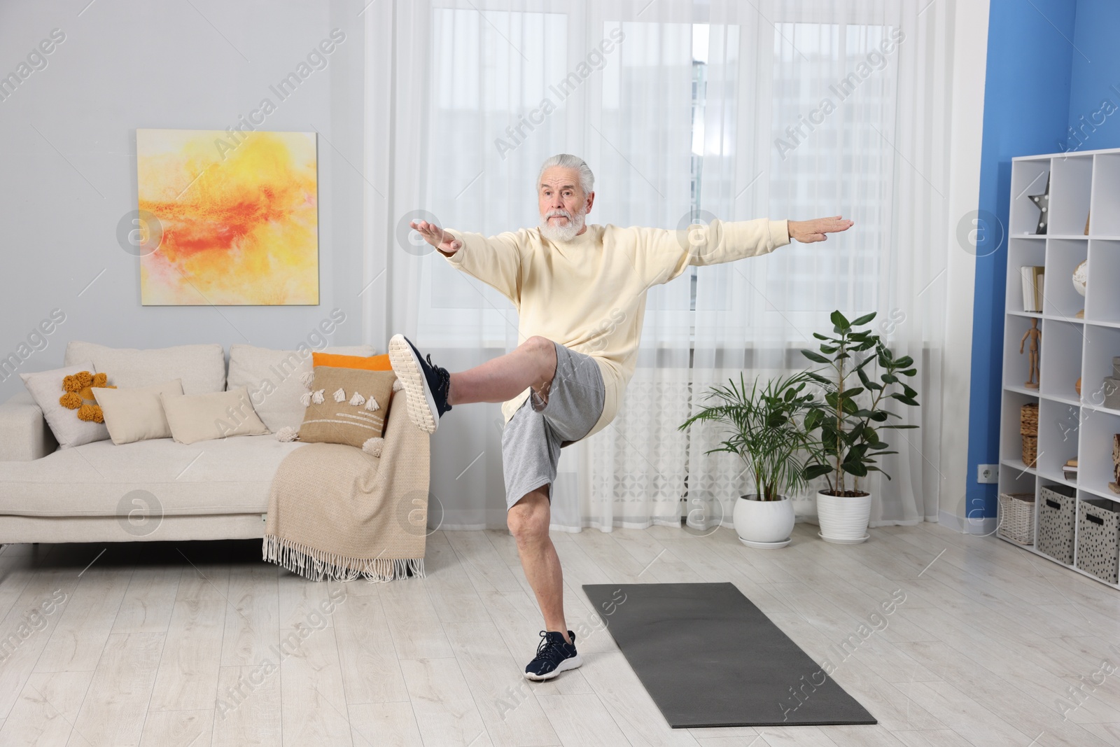 Photo of Elderly man exercising at home. Healthy leisure