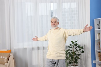 Photo of Elderly man exercising at home. Healthy leisure