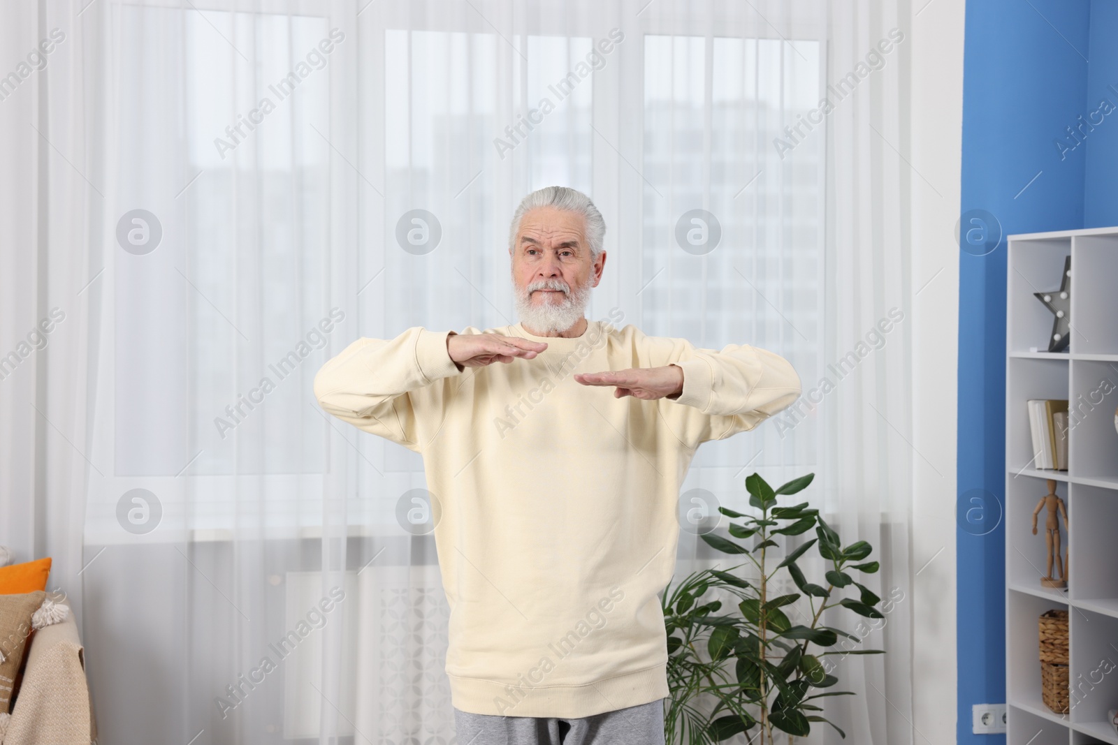 Photo of Elderly man exercising at home. Healthy leisure